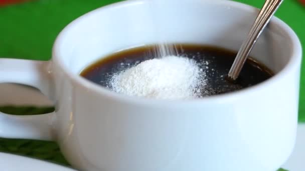 用勺子在一杯香浓咖啡中搅拌砂糖的特写 一杯香浓的咖啡放在一张木制桌子上 — 图库视频影像
