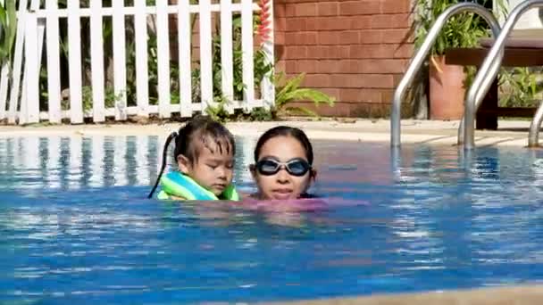 幸せな女の子学ぶへプールで泳ぐ彼女のお母さんとともに熱い夏の日に休暇中 — ストック動画