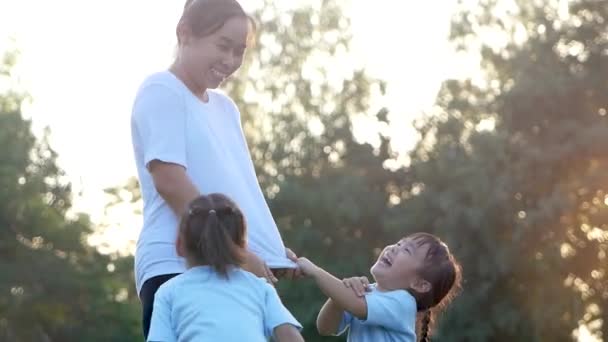 屋外の夏の公園で一緒に運動する2人の小さな女の子と母親 休暇中の家族の健康管理 — ストック動画