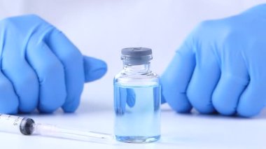 Doktor, hastanede iğne ve ampulle aşı malzemesi tutuyor. El ele tutuşma şırıngası ve aşı. Sağlık ve Tıbbi Konseptler.