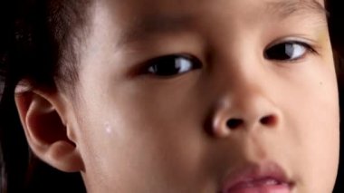 Evdeki karanlık odada gözlerinde hüzün ve dargınlıkla kameraya bakarken küçük sevimli kızın yakın plan portresi uykusunu kaçırıyor. Mutsuz bir çocukluk konsepti.