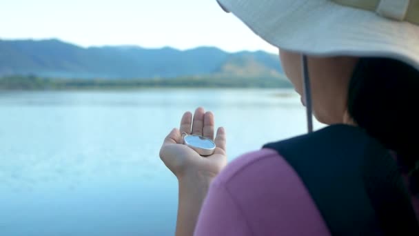 近照一个女旅行家手里拿着指南针准备在日落湖边旅行 生活方式和假期概念 — 图库视频影像