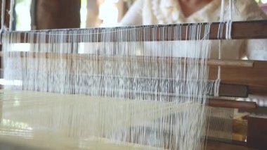 Asyalı yaşlı kadın el yapımı antika dokuma tezgahında ipek kumaş örüyor. İpek böceği kozalarından elde üretilen el yapımı ipek kumaş. Tayland 'da Geleneksel İpek Üretimi.