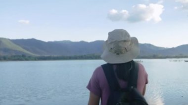 Genç bayan turistler güzel günbatımı gölü arka planında akıllı telefonlardan sohbet ediyorlar. Yaşam tarzı ve Tatil kavramları.