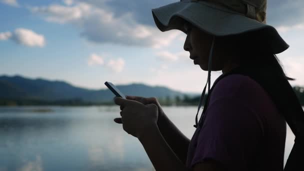 Silhueta Tiro Jovens Turistas Usando Smartphone Fundo Belo Lago Pôr — Vídeo de Stock