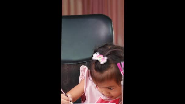 Милая Маленькая Девочка Рисует Радугу Бумаге Цветными Карандашами Столом Дома — стоковое видео