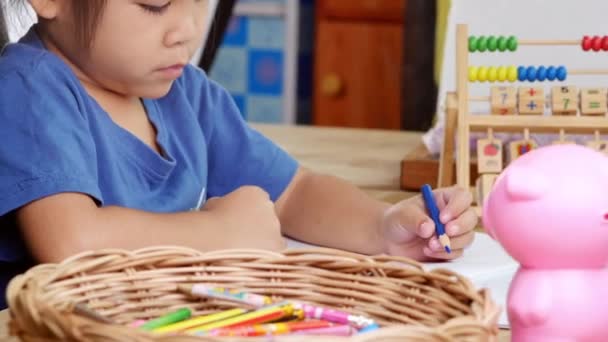 Słodka Dziewczynka Rysuje Tęczę Papierze Kolorowych Ołówków Przy Stole Domu — Wideo stockowe