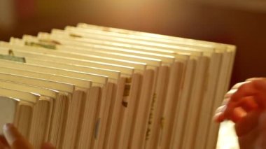 Küçük tatlı bir kızın eli, evdeki kitaplıklardan bir kitap seçiyor. Evde kalıp koronavirüs salgınından karantinaya alın. Ev okulu kavramı.