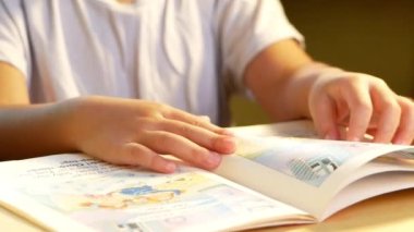 Kitap okuyan küçük tatlı bir kız evde masada oturuyor. Evde kalıp koronavirüs salgınından karantinaya alın. Ev okulu kavramı.