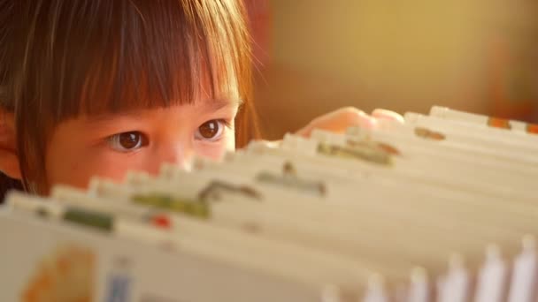 Маленькая Милая Девочка Выбирает Книгу Книжных Полках Дома Оставайтесь Дома — стоковое видео