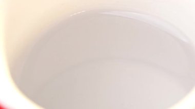 Hazır kahve parçaları kaşıktan fincana dökülüyor. Taze sabah kahvesi. Kapatın..