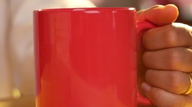 Evde masada oturan genç kadınların eli kitap okurken sıcak kahve içer. Evde kalıp koronavirüs salgınını karantinaya alın..