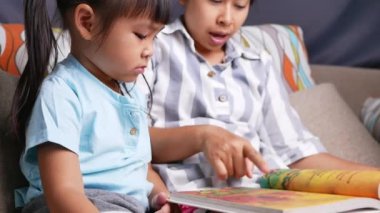 Anne kızıyla birlikte kitap okuyor. Evde kanepede oturuyor ve hafta sonları aile hayatı hobisinin tadını çıkarıyor..