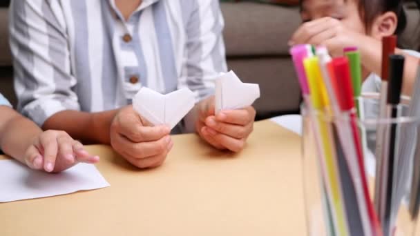 紙を家の中の装飾的な形や人物に折る日本の芸術について学ぶ母親と子供 — ストック動画