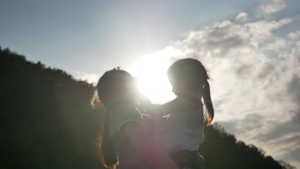 Силует Щасливої Матері Тримає Маленьку Дівчинку Посміхаючись Граючи Фоні Заходу — стокове відео