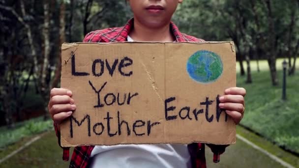 森の中には自然保護看板を掲げた女性ボランティアが立っています 世界環境デーのコンセプト — ストック動画