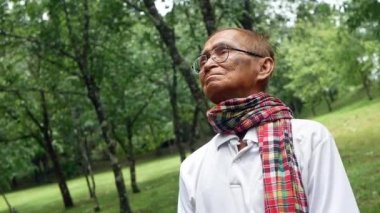 Parkta doğanın tadını çıkaran son sınıf öğrencisinin portresi. Emekli kıdemli adam emeklilik özgürlüğünün tadını çıkarıyor..