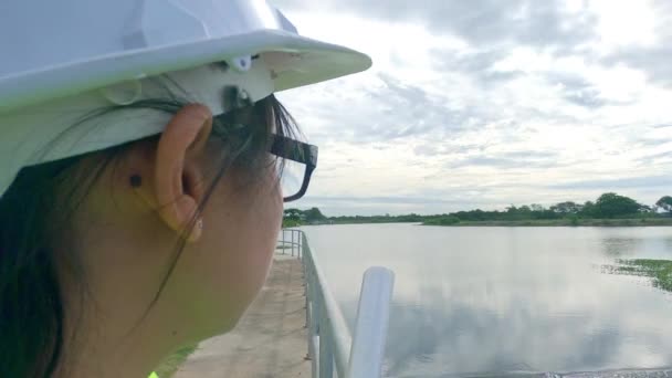 Ingeniera Con Casco Blanco Uniforme Amarillo Sostiene Plano Mira Hacia — Vídeos de Stock