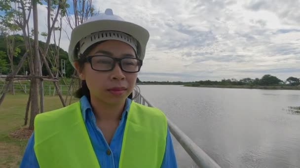 Female Engineer White Helmet Yellow Uniform Holds Blueprint Looking Away — Stock Video