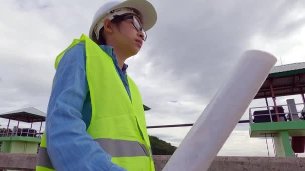 Ingenieurin Mit Weißem Helm Und Gelber Uniform Hält Einen Bauplan — Stockvideo