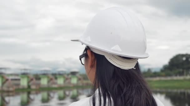 Жінка Інженер Знімає Шолом Безпеки Відпочиваючи Поруч Будівельним Майданчиком Виробництва — стокове відео