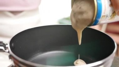 Kadının elini kapat ve evde ısınmak için bir teneke Prego Pasta Spagetti Carbonara Mantar Sosunu elektrikli ocağın üzerine dök. Sağlıklı İtalyan Yemek ve Pişirme kavramları.