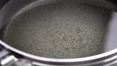 Mutfaktaki elektrikli ocağın üzerinde kaynayan kızgın yağın olduğu bir tavayı kapat. Ev yapımı patates kızartması yapma süreci..