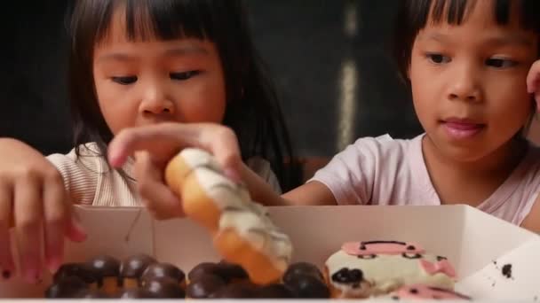 행복하고 스러운 소녀가 박스에서 귀여운 도넛을 — 비디오