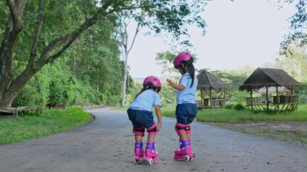 两个兄弟姐妹戴着护垫和安全帽 在公园的街上练习轮滑 积极为儿童提供户外运动 — 图库视频影像
