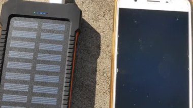 Güneş panelleri ile yeniden şarj edilebilir mobil güç paketi, yakın plan. Bir cep, tablet veya akıllı telefona bağlanıp şarj ediliyor. 