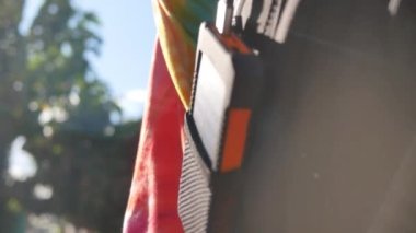 Genç bayan gezginlerin sırt çantasında güneş panelleri olan şarj edilebilir bir cep telefonu. Yakın plan. Bir cep, tablet veya akıllı telefona bağlanıp şarj ediliyor.