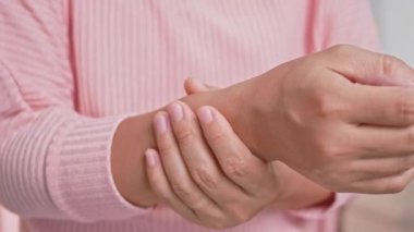 Bilgisayarda ya da ev kadınında yapılan uzun çalışmaların yol açtığı ağrılı bileğini tutan kadın. Karpal tünel sendromu, eklem iltihabı. Nörolojik hastalık kavramı.