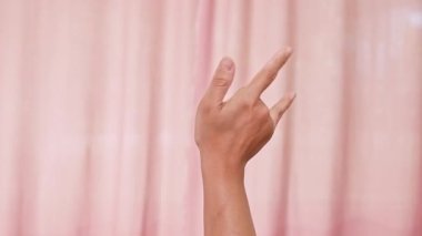 Pembe arka planda I Love You sembolü yapan eller. İşaret diliyle 