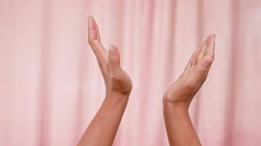 Pembe arka planda izole edilmiş elleri alkışlıyor. Ayrı kadın elleri takdir edilmenin sembolünü alkışlıyor. İşaret dili.