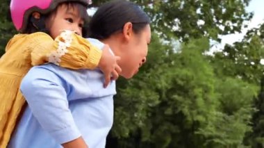 Mutlu anne, yaz parkında tatlı kızıyla bisiklet sürerken eğlenmeyi sever. Aileler tatilde boş zamanlarını birlikte geçirirler..
