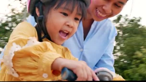 安全ヘルメットのかわいい女の子は 夏の公園で母親と一緒に自転車に乗ることを学ぶ 子供のための屋外スポーツ 子供の頃の幸せ 家族で過ごす時間は — ストック動画