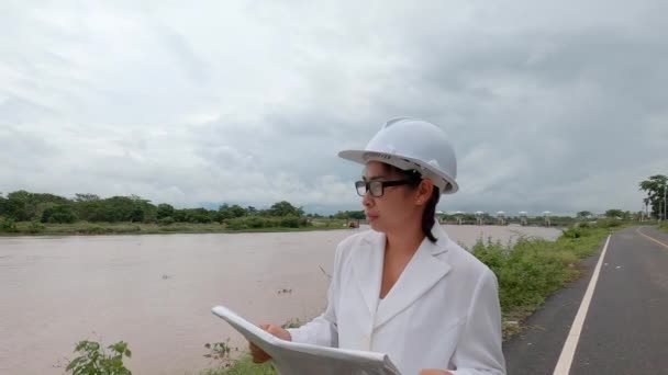 Ženský Inženýr Držící Plán Prochází Kolem Elektrifikační Hráze Řeky Aby — Stock video
