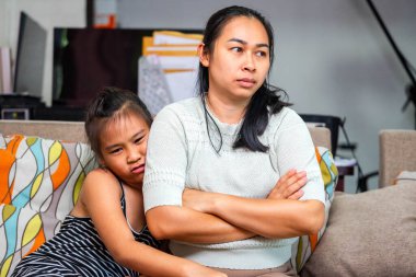 Evde anlaşmazlık yaşayan Asyalı bir anne ve kızı. Resim, aile içi çatışma, ebeveynlik gerginliği ve duygusal ifadeyi gösteriyor, ilişki sorunları, iletişim sorunları veya ebeveynlik kavramları için uygun.