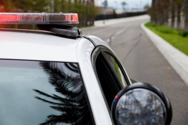 Arka planda fren izleri olan bir polis arabasının yakın çekimi..