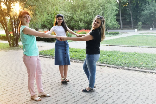 Три Молодые Улыбающиеся Женщины Подруги Держатся Руки Кругу Лучами Вечернего — стоковое фото