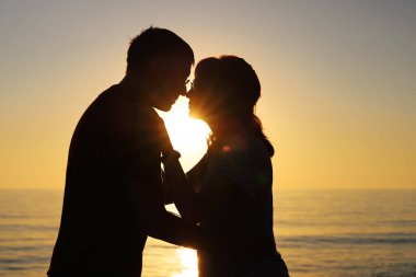 Aralarındaki güneşin parlak ışığına aşık çiftlerin silueti. Güçlü ilişki ve aşk kavramı