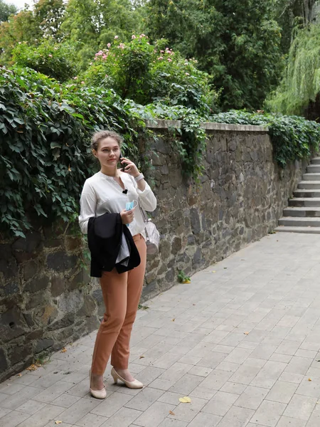 Takım Elbiseli Genç Bir Kadın Parkta Tek Başına Duruyor Akıllı — Stok fotoğraf