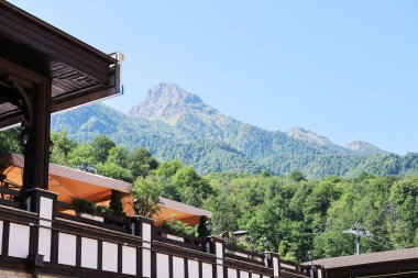 Dağların yumuşak odak noktası ve ön planda turizm ve eğlence için bina fotokopi alanı ile güneşli yaz gününde