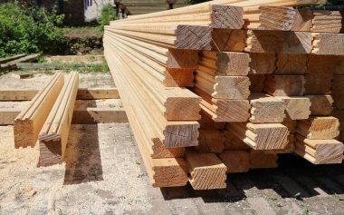 Tahta kereste kalibre edilmiş kereste yığını, güneşli bir günde gökyüzünün altında ev inşa etmek için.