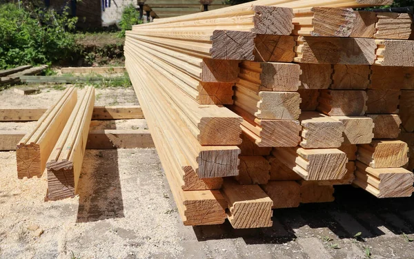 Tahta kereste kalibre edilmiş kereste yığını, güneşli bir günde gökyüzünün altında ev inşa etmek için.