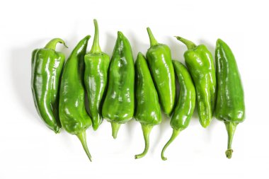 Sıraya dizilmiş çiğ yeşil tatlı biber grubu, beyaz arkaplanda izole edilmiş yakın çekim