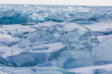 Manzaralı kış gölü Baykal manzarası. Yüzeyinde büyük basınç sırtı şeffaf buz blokları var.