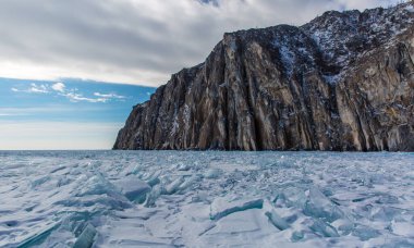 Manzaralı kış gölü Baykal manzarası. Yüzeyinde büyük basınç sırtı şeffaf buz blokları var.