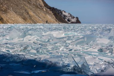 Manzaralı kış gölü Baykal manzarası. Yüzeyinde büyük basınç sırtı şeffaf buz blokları var.