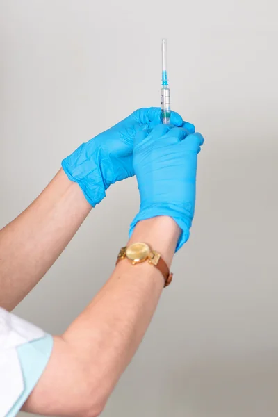 As mãos mantêm a seringa em luvas médicas de borracha — Fotografia de Stock